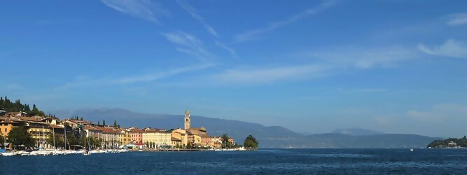 Trip Croatia beliebte Urlaubsziele am Gardasee -  Mit einer Fläche von 370 km² ist der Gardasee der größte See Italiens. Es liegt am Fuße der Alpen und erstreckt sich über drei Staaten: Lombardei, Venetien und Trentino. Die maximale Tiefe des Sees beträgt 346 m, er hat eine längliche Form und sein nördliches Ende ist sehr schmal. Dort ist der See von den Bergen der Gruppo di Baldo umgeben. Du trittst aus deinem gemütlichen Hotelzimmer und es begrüßt dich die warme italienische Sonne. Du blickst auf den atemberaubenden Gardasee, der in zahlreichen Blautönen schimmert - von tiefem Dunkelblau bis zu funkelndem Türkis. Majestätische Berge umgeben dich, während die Brise sanft deine Haut streichelt und der Duft von blühenden Zitronenbäumen deine Nase kitzelt. Du schlenderst die malerischen, engen Gassen entlang, vorbei an farbenfrohen, blumengeschmückten Häusern. Vereinzelt unterbricht das fröhliche Lachen der Einheimischen die friedvolle Stille. Du fühlst dich wie in einem Traum, der nicht enden will. Jeder Schritt führt dich zu neuen Entdeckungen und Abenteuern. Du probierst die köstliche italienische Küche mit ihren frischen Zutaten und verführerischen Aromen. Die Sonne geht langsam unter und taucht den Himmel in ein leuchtendes Orange-rot - ein spektakulärer Anblick.